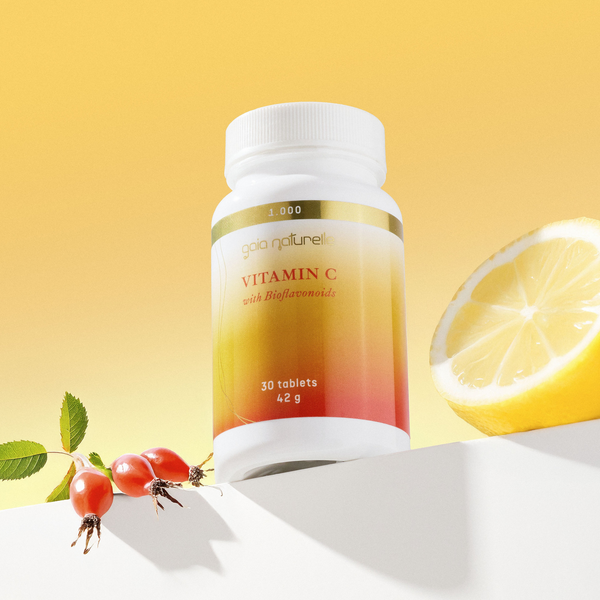 Vitamin C supplement bottle with a lemon and berries on a yellow background, GAIA NATURELLE